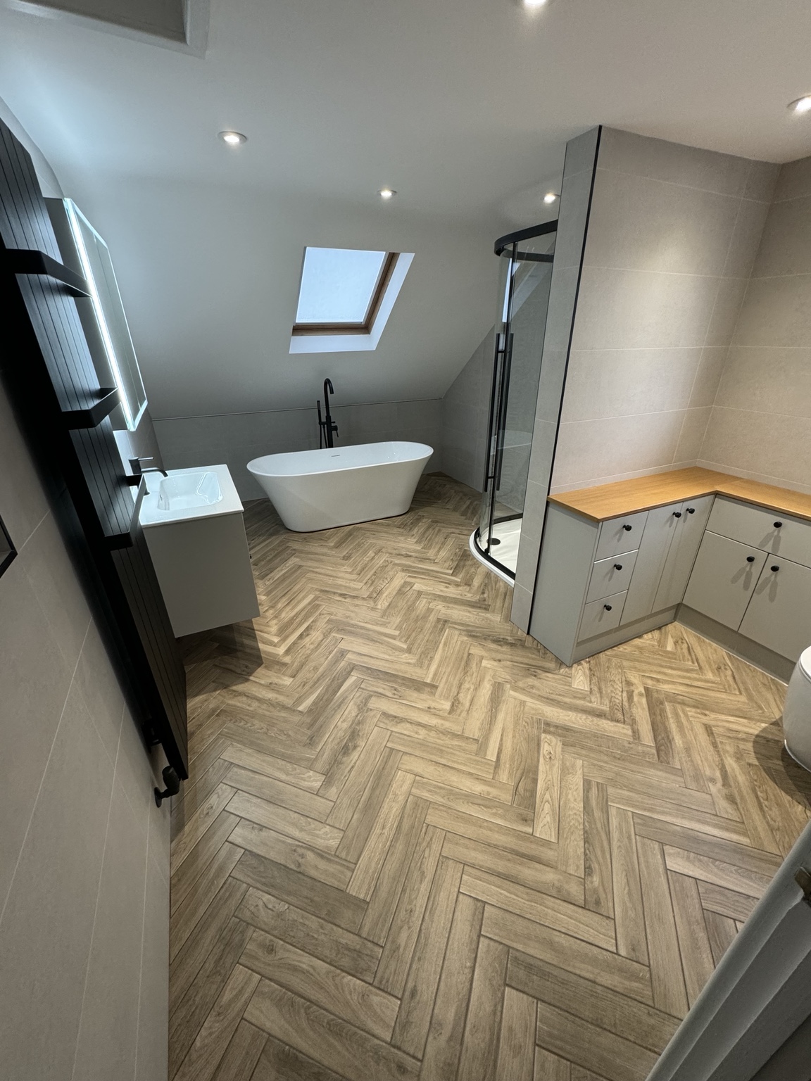 Loft bathroom with freestanding bath, shower and herringbone floor